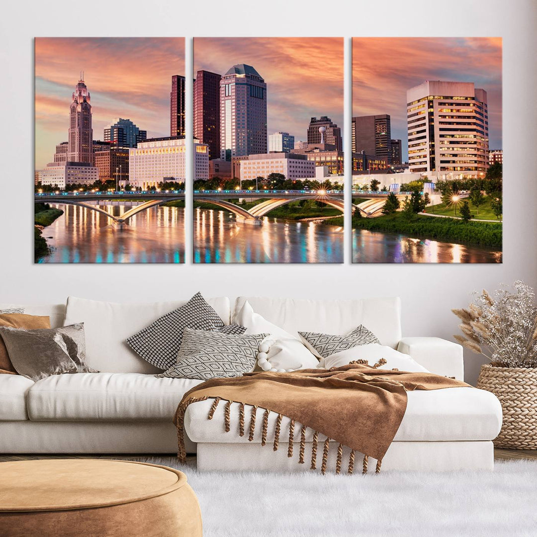 The "Columbus City Lights Sunset Orange Cloudy Skyline Cityscape View" wall art is featured on the wall. This triptych is printed on museum-quality canvas and includes a UV-protective coating, ensuring lasting vibrancy.