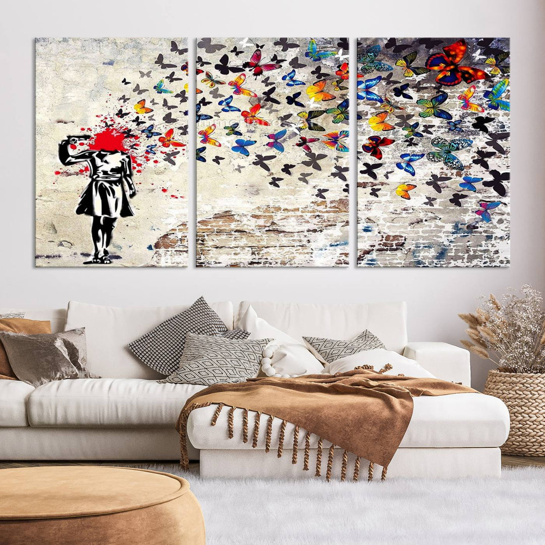 The Banksy Art Butterfly Girl Explosion Canvas showcases a dynamic figure with butterflies bursting from their head, set against a textured wall background. This vibrant urban graffiti piece is perfect for modern interiors and comes ready to hang.