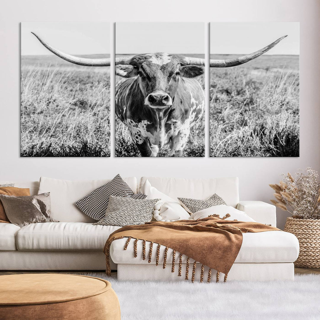 The Texas Cow Longhorn Wall Art Canvas Print is a black and white triptych depicting a cow in a field. It is crafted with museum-quality canvas and features a UV-protective coating.