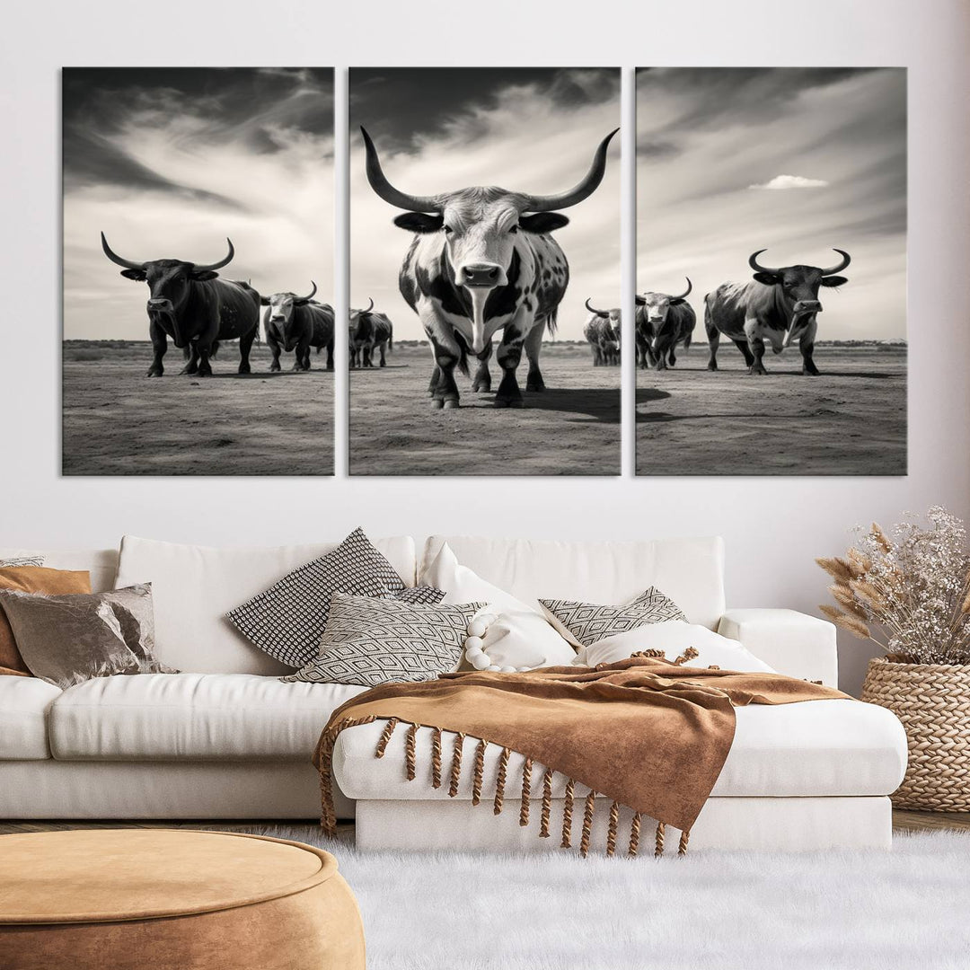 The Black and White Longhorn Cattle Wall Art, featuring a three-panel display of cowboy Western longhorns walking toward the viewer, enhances your space with its striking presence, adding a touch of Western decor.