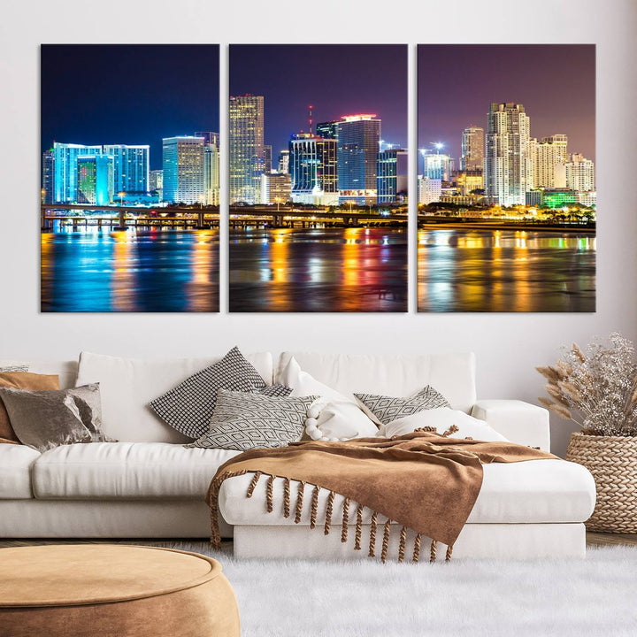 The Wall Art MIAMI Canvas Print features a stunning triptych of a city skyline at night, with vibrant lights reflecting on the water. This gallery-wrapped piece on museum-quality canvas delivers an exquisite finish.