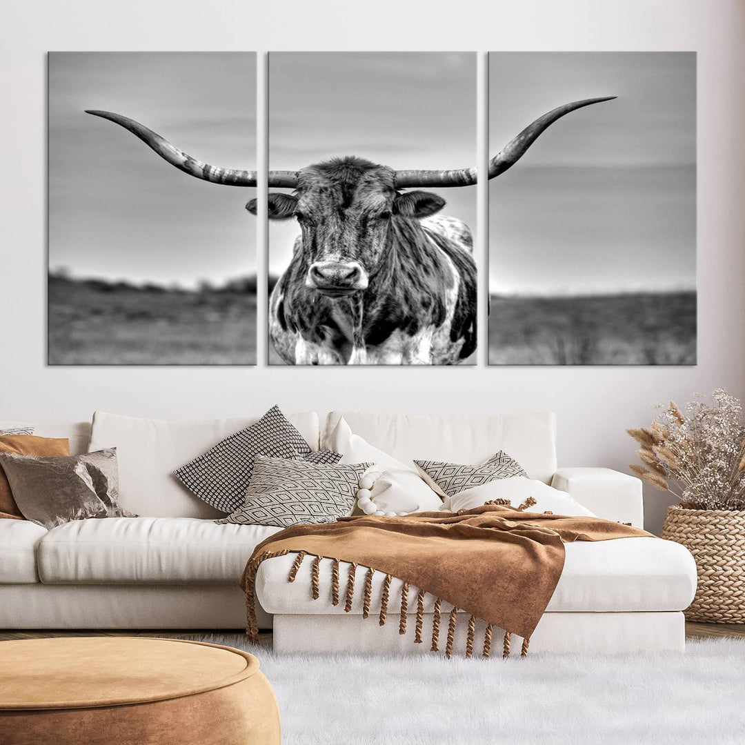 The Texas Longhorn Cow Wall Art, featuring a black and white image of a longhorn bull on canvas, brings charm to the room with its sophisticated appeal.