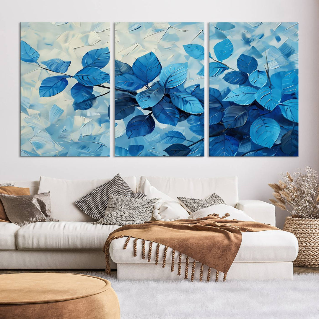 The contemporary living room is highlighted by the Abstract Blue Leaf Wall Art Canvas Print on the wall. The hand-assembled framed art enhances the room's vibrant decor, crafting a gallery-worthy ambience.