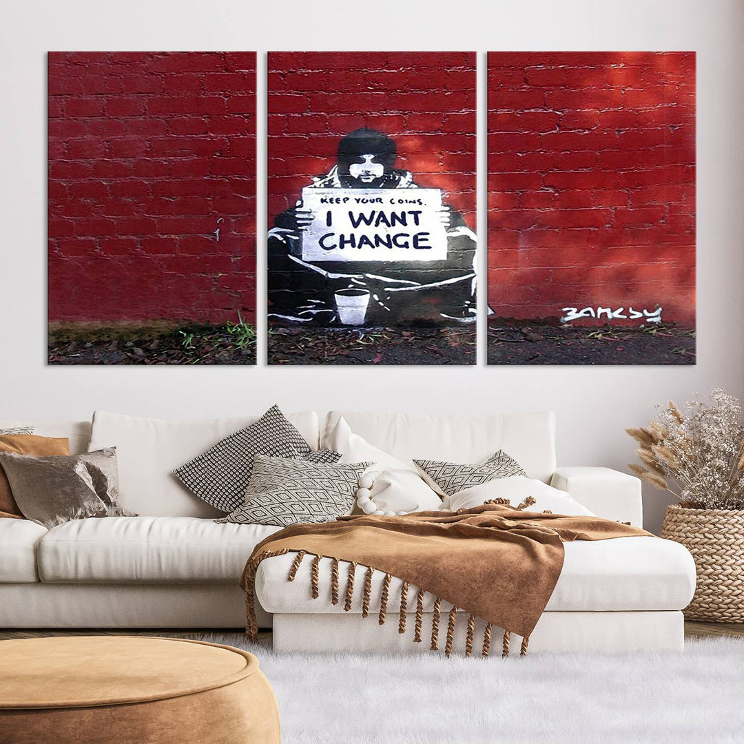 The living room showcases a triptych of stencil artwork on museum-quality canvas, featuring the Banksy I Want Change Graffiti Abstract Wall Art Canvas Print. This captivating piece depicts a person holding a sign that says "I want change" and is finished with a UV-protective coating to ensure long-lasting beauty.