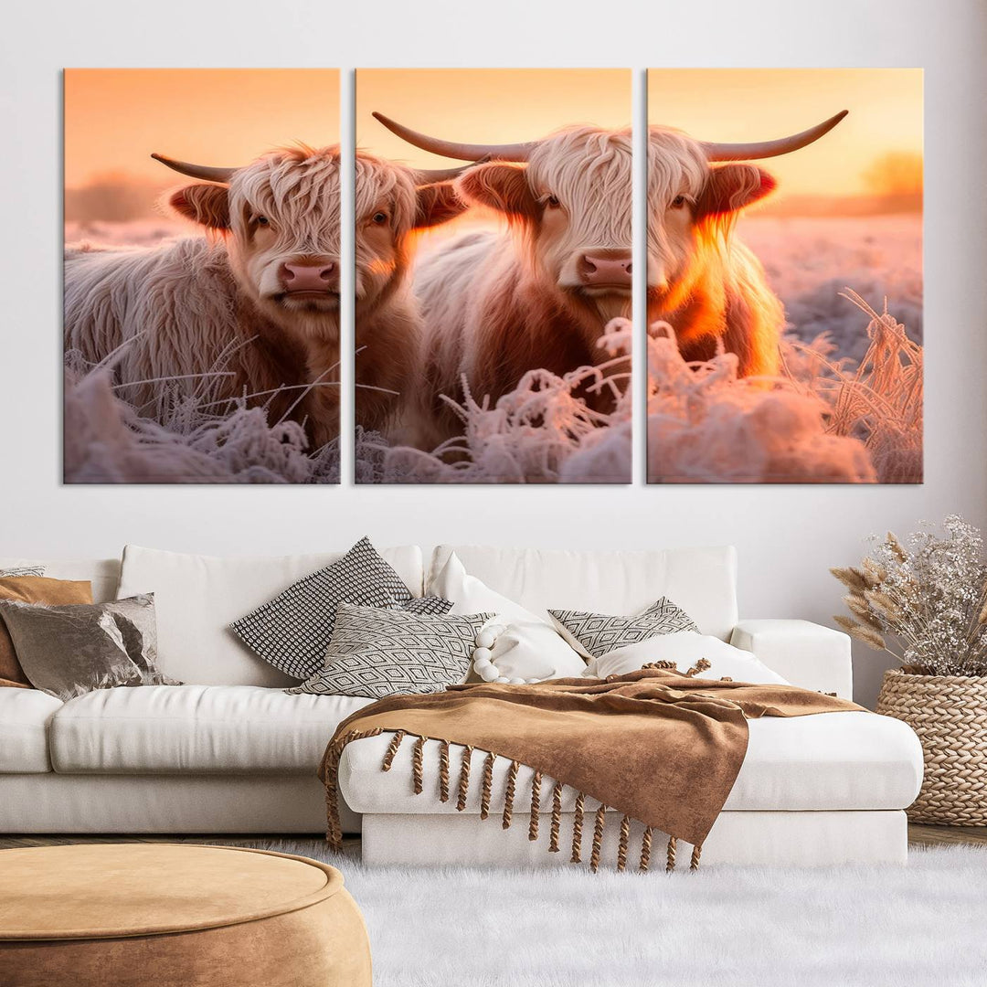 The "Highland Cows at Sunrise Wall Art Canvas Set" beautifully captures a serene and rustic farmhouse aesthetic, portraying two Highland cows in a frosty landscape at sunrise.