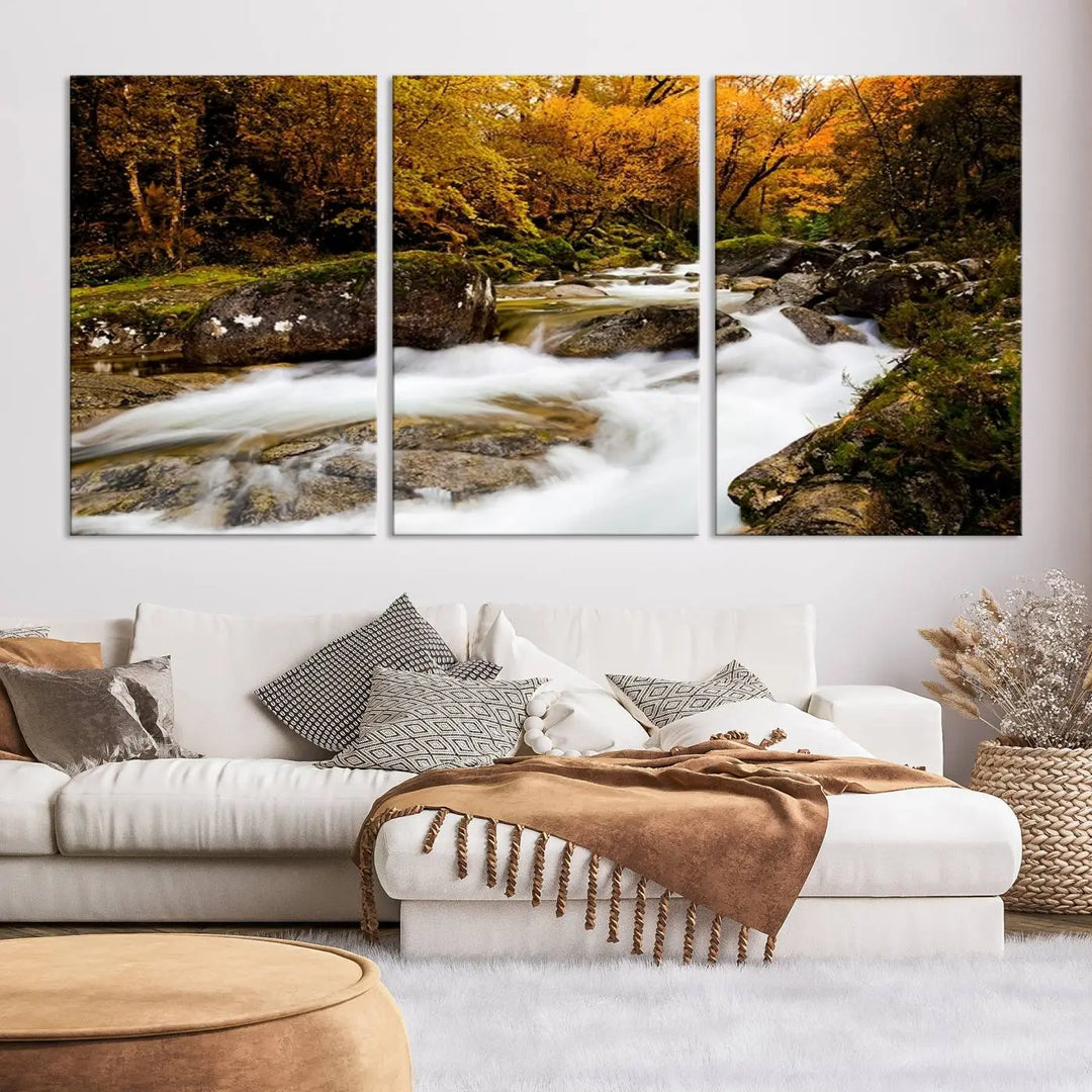 The living room is adorned with the "Wall Art Waterfall Canvas Print River in Forest in Autumn," a triptych on museum-quality canvas showcasing a flowing river surrounded by autumn trees. This ready-to-hang artwork features a UV-protective coating to ensure enduring vibrancy.