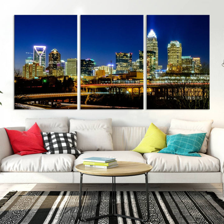 The Charlotte City Lights Night Blue Skyline Cityscape View Wall Art Canvas Print, showcasing an illuminated city skyline at night, is printed on museum-quality canvas with a UV-protective coating. Enhance your space with this stunning piece and enjoy free shipping with your purchase.