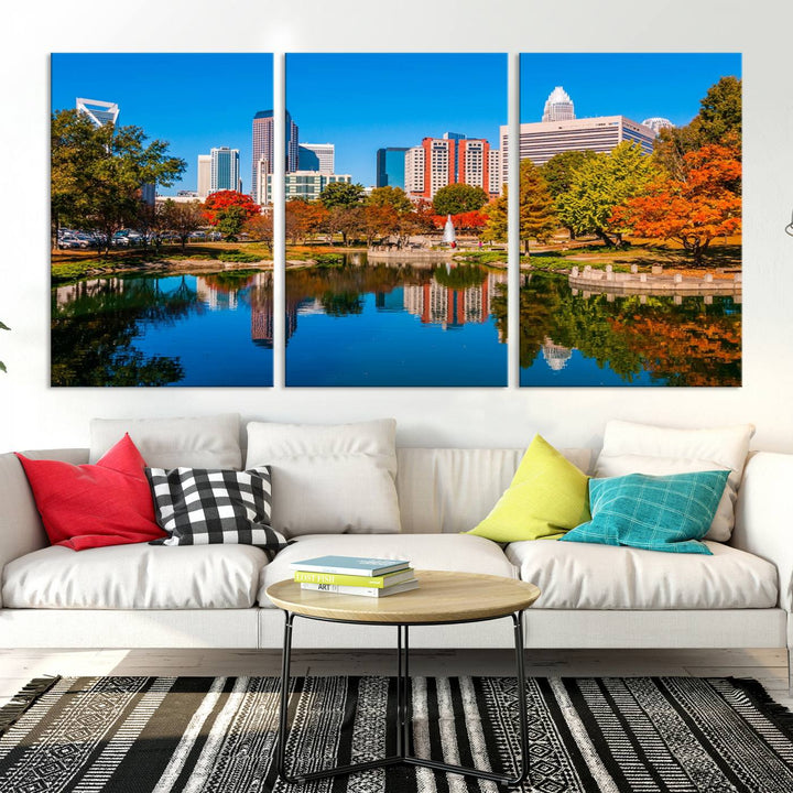 The "Charlotte City Autumn Morning Blue Skyline Cityscape View Wall Art Canvas Print" showcases a cityscape with vibrant autumn trees reflected in a lake. Its gallery-wrapped edges add depth to the scene, while the UV-protective coating ensures lasting brilliance.