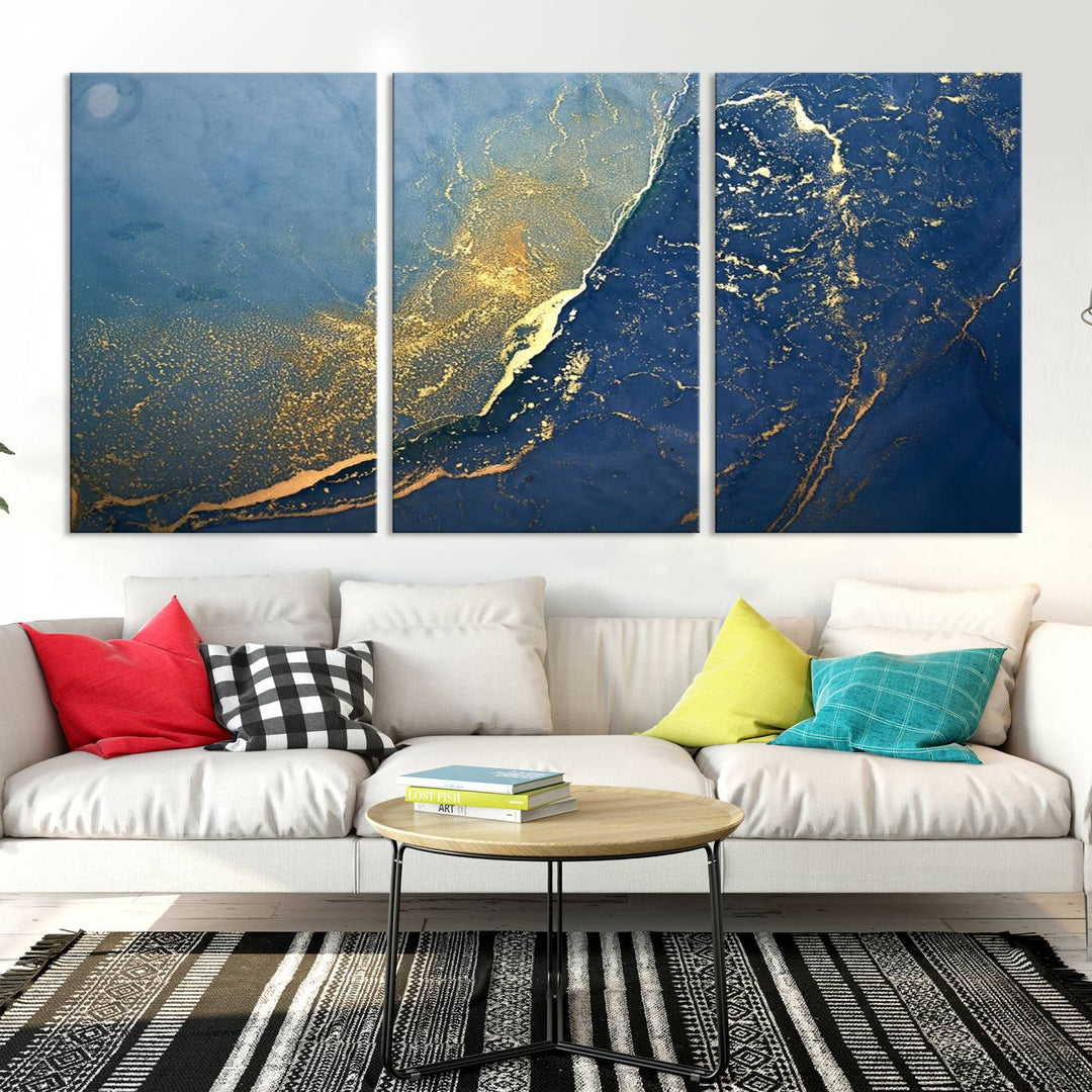 The Navy Blue Yellow Twinkle Wall Art Canvas Print, featuring an abstract design in gold and blue, enhances a modern living room as it adorns a white wall with its gallery-wrapped, museum-quality canvases for an exquisite touch.