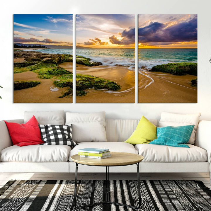 The Sunset Beach Wall Art Canvas Print is a gallery-wrapped triptych showcasing a beach scene with mossy rocks and a vibrant sunset. Made from museum-quality canvas and featuring a UV-protective coating, it elegantly provides both beauty and durability.