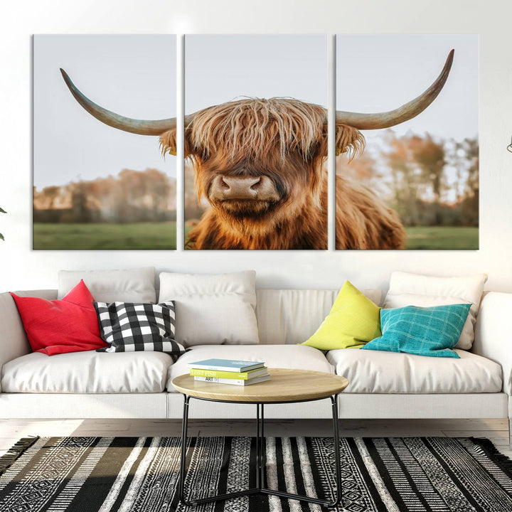 A Highland Cow Animal Scottish Cattle Art Print Farmhouse Wall Art Canvas Print hangs in the living room, adding a touch of rustic farmhouse decor.