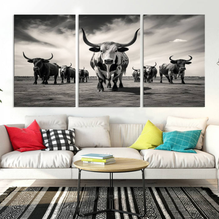 The Black and White Longhorn Cattle Wall Art, featuring a three-panel display of cowboy Western longhorns walking toward the viewer, enhances your space with its striking presence, adding a touch of Western decor.