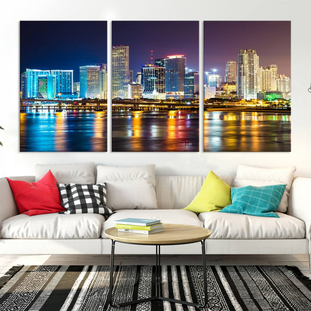 The Wall Art MIAMI Canvas Print features a stunning triptych of a city skyline at night, with vibrant lights reflecting on the water. This gallery-wrapped piece on museum-quality canvas delivers an exquisite finish.