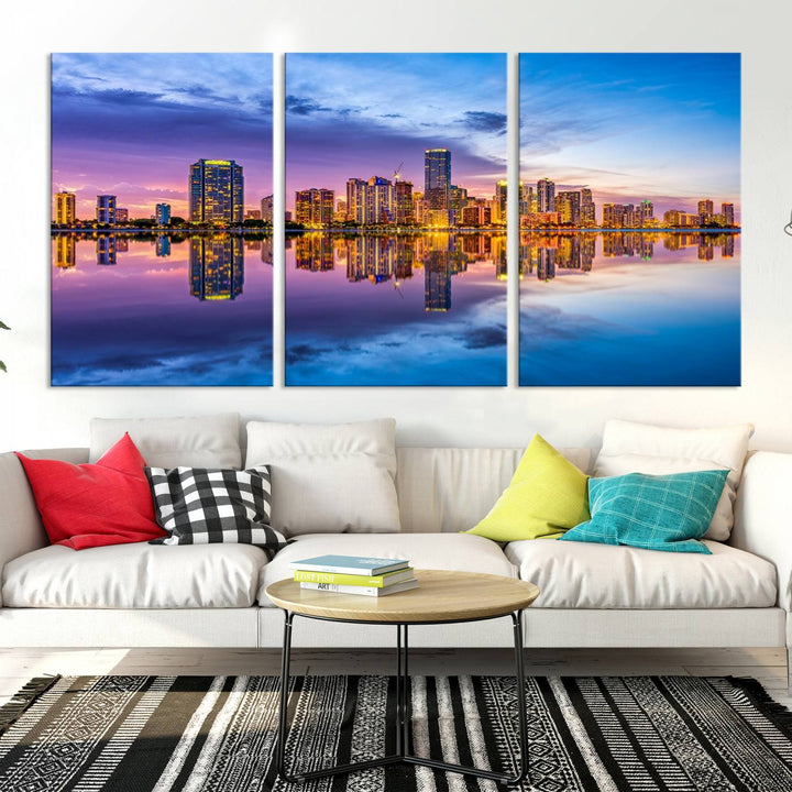 The Miami City Wall Art Canvas Print, featuring a three-panel depiction of a city skyline at sunset reflected in water, beautifully enhances the wall. Made with museum-quality canvas and a UV-protective coating, it comes ready to hang.