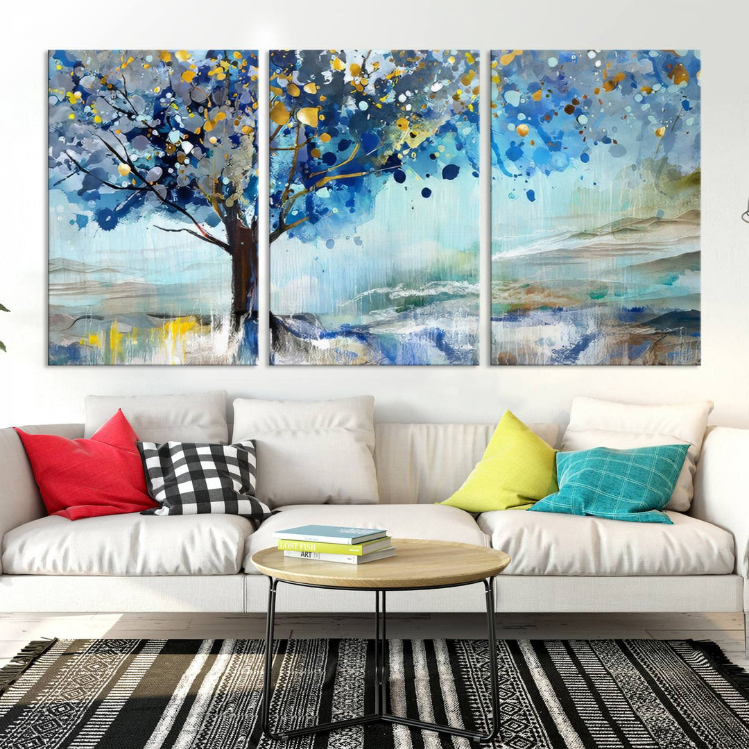 A modern living room features a three-panel Watercolor Style Abstract Tree Printing Wall Art Canvas in vibrant blue and yellow, crafted on museum-quality material.