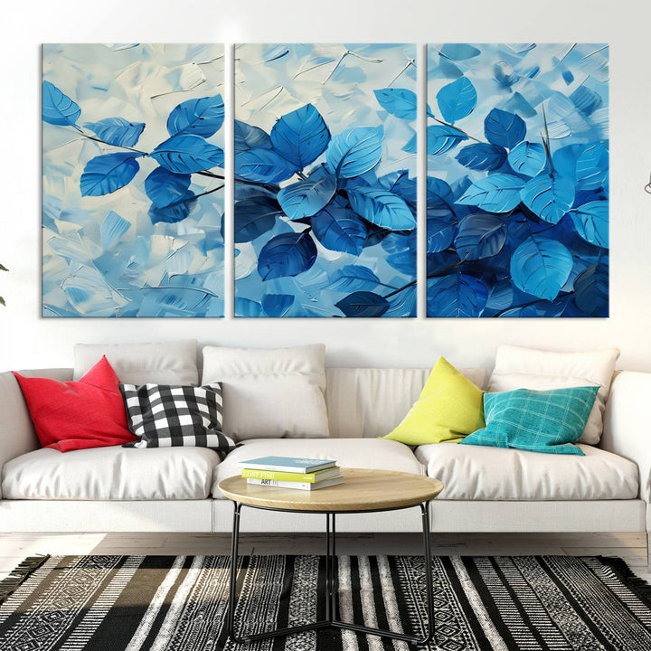 The contemporary living room is highlighted by the Abstract Blue Leaf Wall Art Canvas Print on the wall. The hand-assembled framed art enhances the room's vibrant decor, crafting a gallery-worthy ambience.