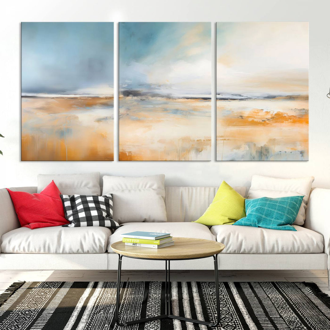 The Abstract Landscape Wall Art Canvas Print, featuring warm tones of orange and blue, is displayed on a dark wall.