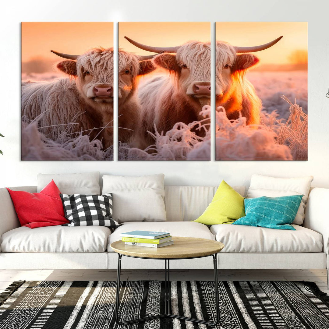 The "Highland Cows at Sunrise Wall Art Canvas Set" beautifully captures a serene and rustic farmhouse aesthetic, portraying two Highland cows in a frosty landscape at sunrise.