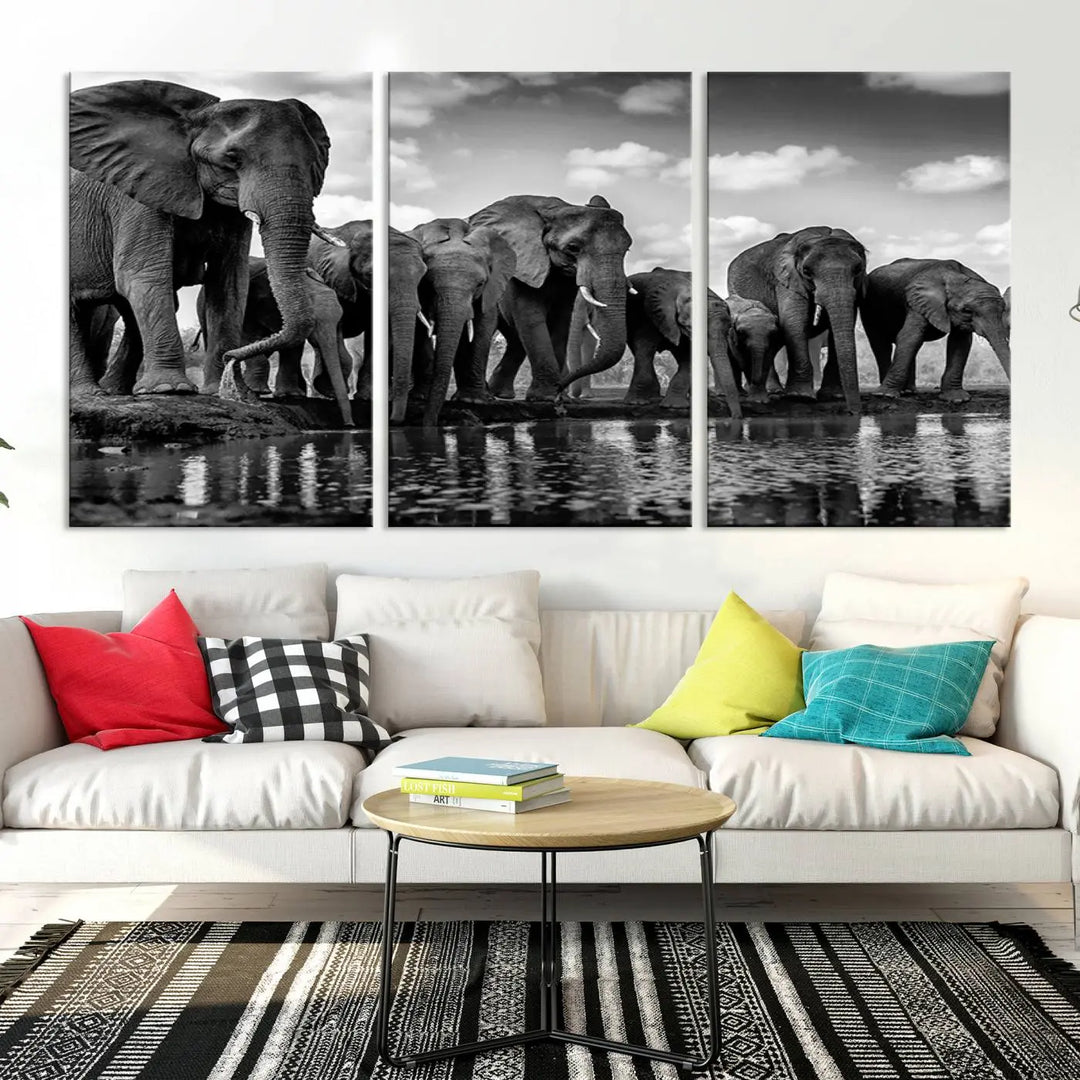 A stunning "Wall Art Animal Canvas Print" featuring a black and white photo of a herd of elephants drinking water is elegantly displayed, gallery wrapped on museum-quality canvas.