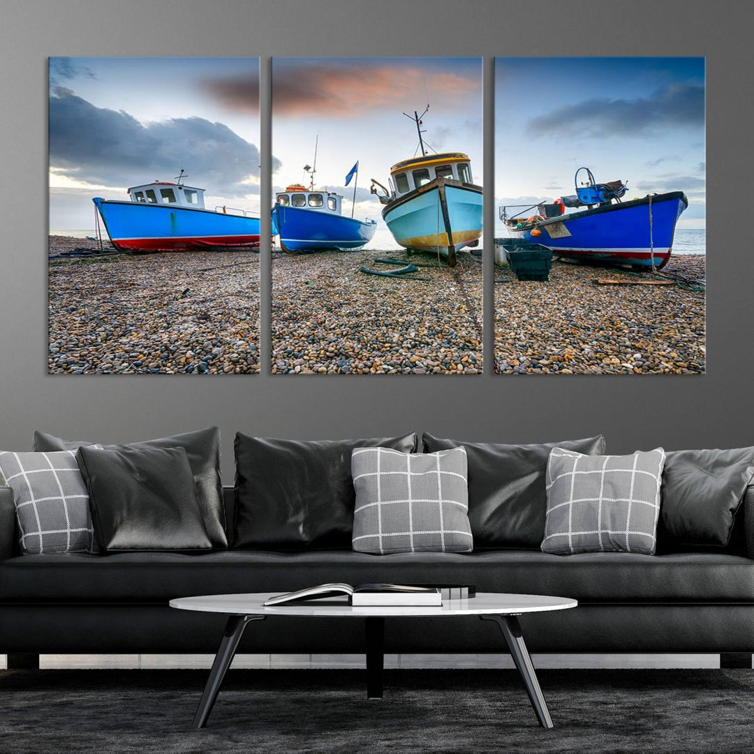 The "Big Boats On The Beach Wall Art Canvas Print" is a stunning piece featuring three museum-quality panels depicting fishing boats on a pebbled shore. Ready to hang and featuring UV-protective coating, it serves as an elegant addition to your home décor.