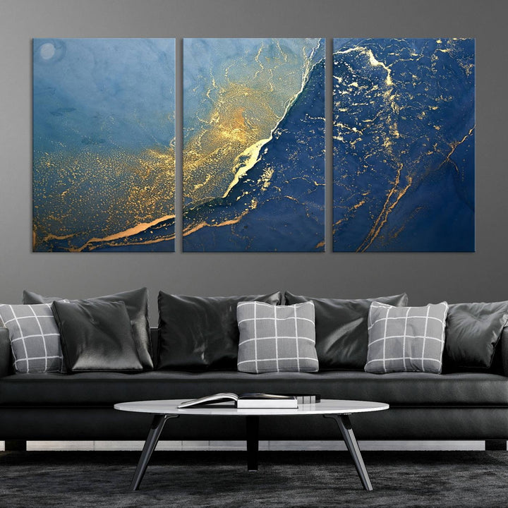 The Navy Blue Yellow Twinkle Wall Art Canvas Print, featuring an abstract design in gold and blue, enhances a modern living room as it adorns a white wall with its gallery-wrapped, museum-quality canvases for an exquisite touch.