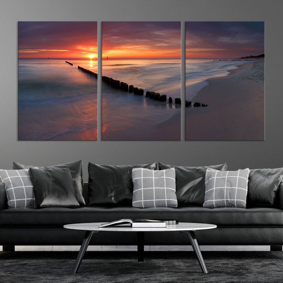 In a modern living room, the Sunset Beach Wall Art Canvas Print is displayed above. This triptych, printed on museum-quality canvas with a UV-protective coating, ensures lasting brilliance. It's ready to hang and brings an elegant touch to your space.