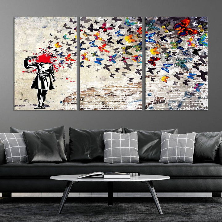 The Banksy Art Butterfly Girl Explosion Canvas showcases a dynamic figure with butterflies bursting from their head, set against a textured wall background. This vibrant urban graffiti piece is perfect for modern interiors and comes ready to hang.