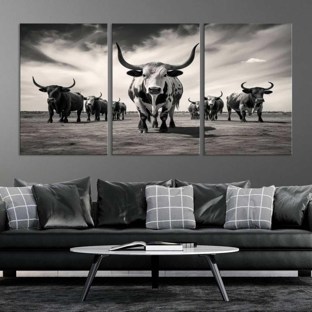 The Black and White Longhorn Cattle Wall Art, featuring a three-panel display of cowboy Western longhorns walking toward the viewer, enhances your space with its striking presence, adding a touch of Western decor.