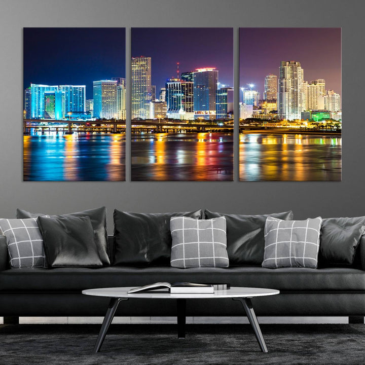 The Wall Art MIAMI Canvas Print features a stunning triptych of a city skyline at night, with vibrant lights reflecting on the water. This gallery-wrapped piece on museum-quality canvas delivers an exquisite finish.