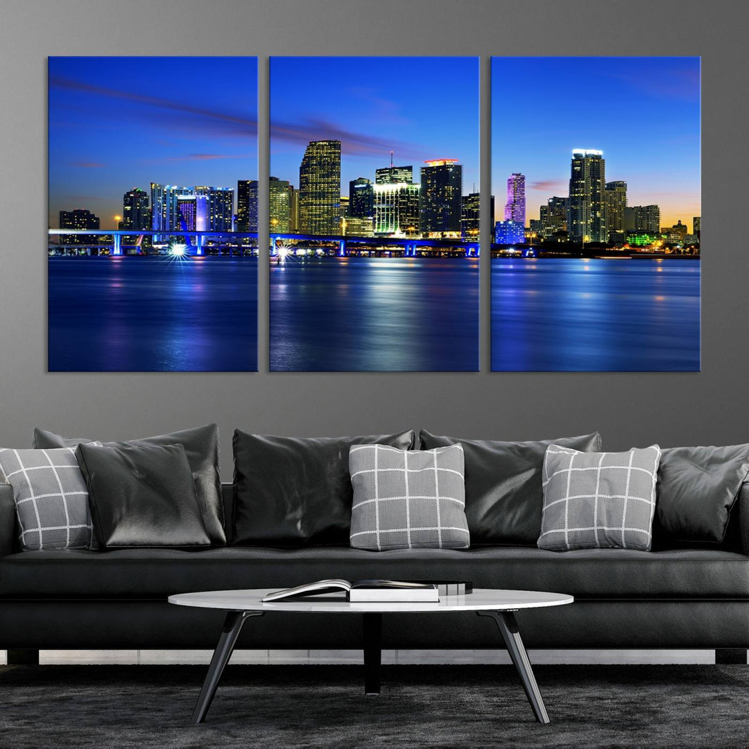 The modern living room showcases a striking Miami Blue Night Wall Art canvas print on the wall. The artwork is gallery wrapped on museum-quality canvas, ensuring durability and elegance.