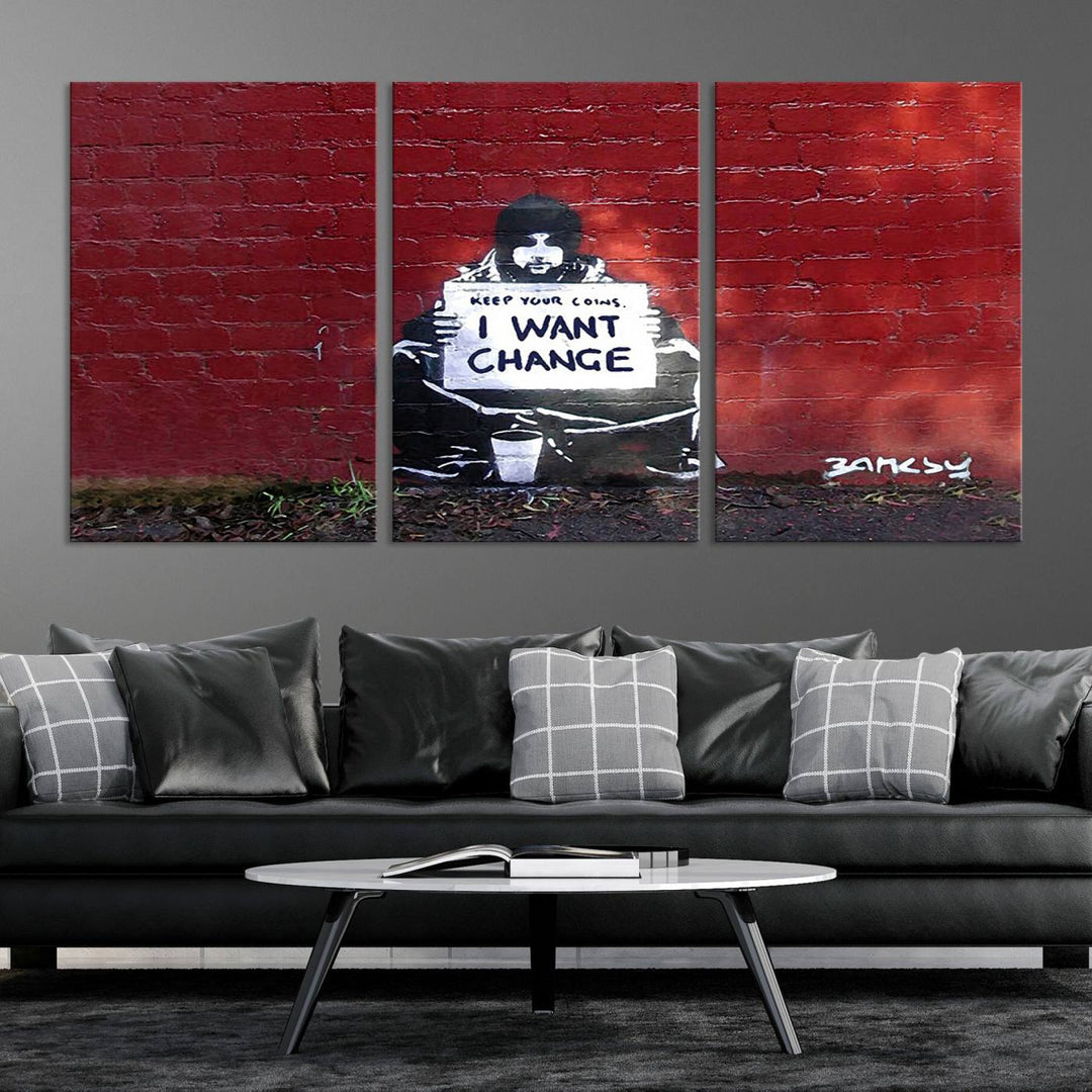 The living room showcases a triptych of stencil artwork on museum-quality canvas, featuring the Banksy I Want Change Graffiti Abstract Wall Art Canvas Print. This captivating piece depicts a person holding a sign that says "I want change" and is finished with a UV-protective coating to ensure long-lasting beauty.