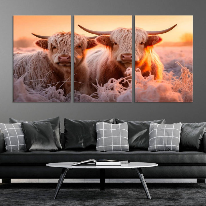 The "Highland Cows at Sunrise Wall Art Canvas Set" beautifully captures a serene and rustic farmhouse aesthetic, portraying two Highland cows in a frosty landscape at sunrise.