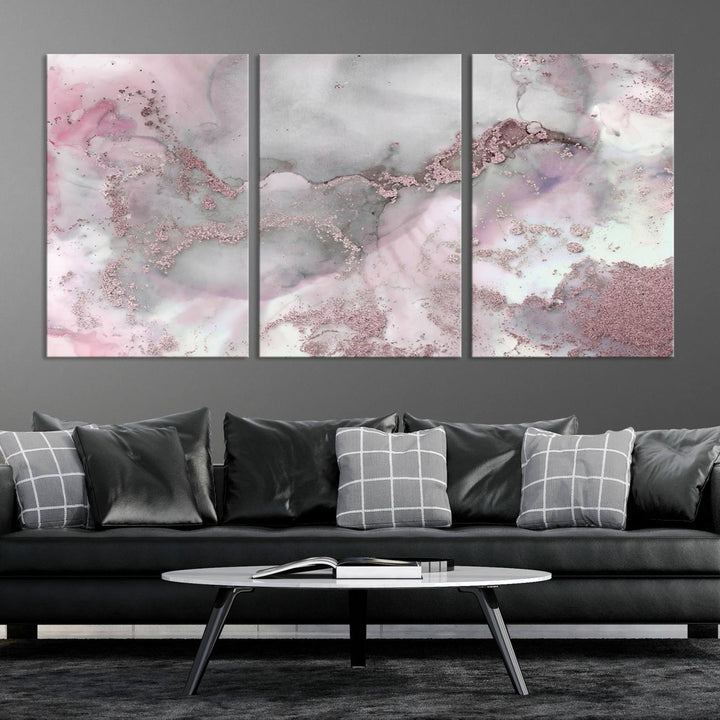 The Rose Marble Abstract Wall Art Canvas Print is a stunning triptych that showcases pink and gray tones, elegantly presented on a dark wall.