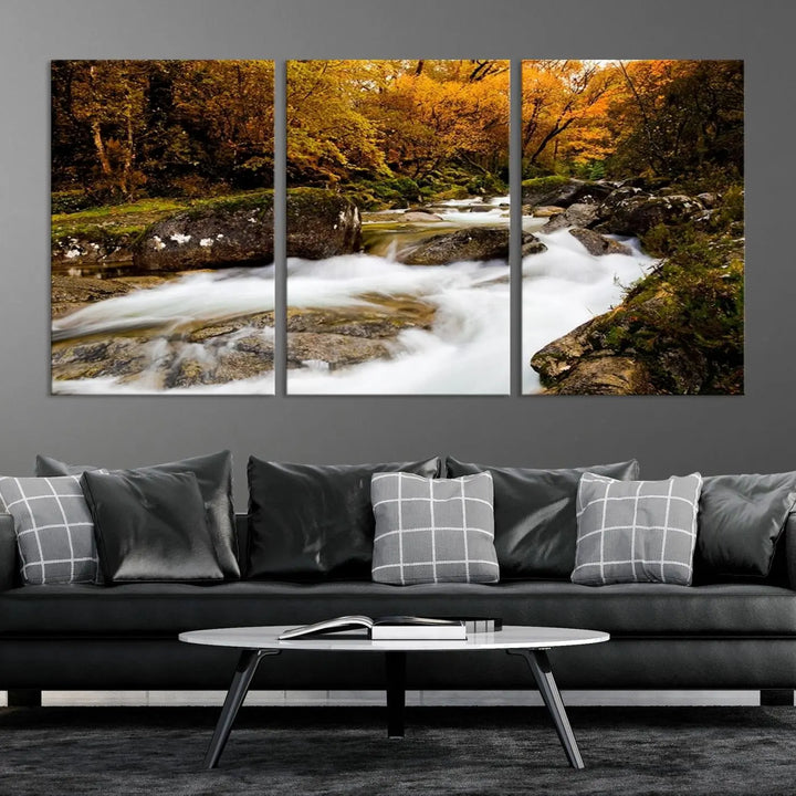 The living room is adorned with the "Wall Art Waterfall Canvas Print River in Forest in Autumn," a triptych on museum-quality canvas showcasing a flowing river surrounded by autumn trees. This ready-to-hang artwork features a UV-protective coating to ensure enduring vibrancy.