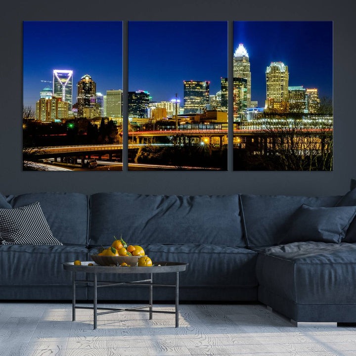 The Charlotte City Lights Night Blue Skyline Cityscape View Wall Art Canvas Print, showcasing an illuminated city skyline at night, is printed on museum-quality canvas with a UV-protective coating. Enhance your space with this stunning piece and enjoy free shipping with your purchase.