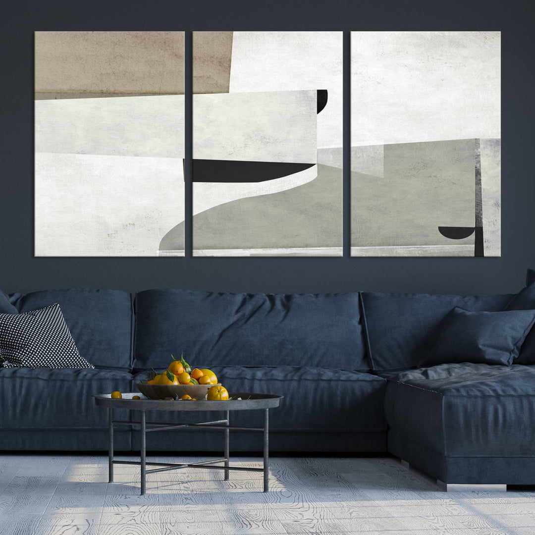 The Brown Gray Figures Abstract Wall Art Canvas Print is displayed as a triptych on a dark wall. The piece is gallery wrapped, offering a seamless finish and enhanced durability due to its UV-protective coating.