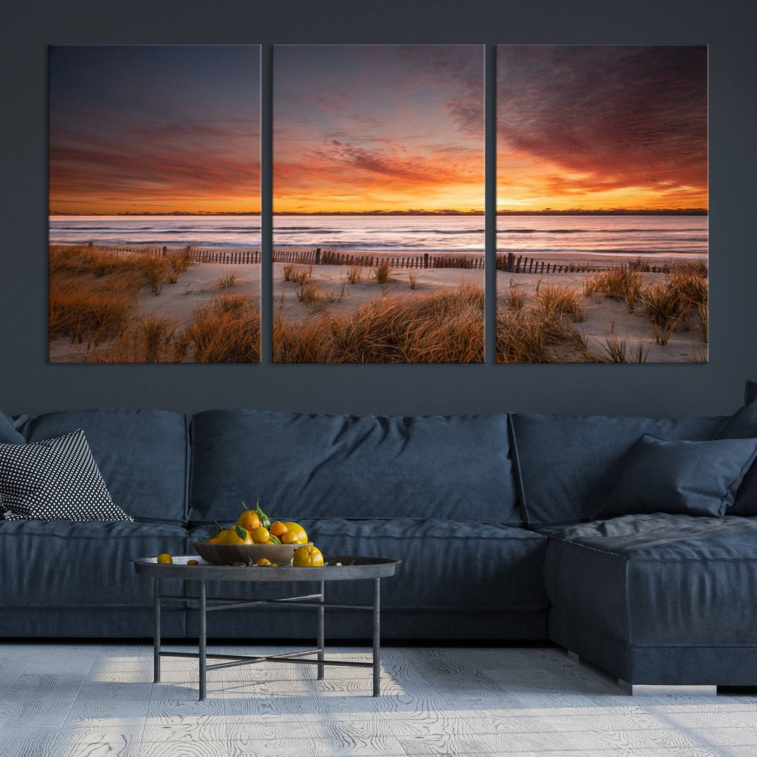 Sunset on The Beach Wall Art Canvas Print features a triptych of a beach at sunset with vivid orange skies, presented on museum-quality canvas. Each section is gallery wrapped, offering lasting beauty with its UV-protective coating.