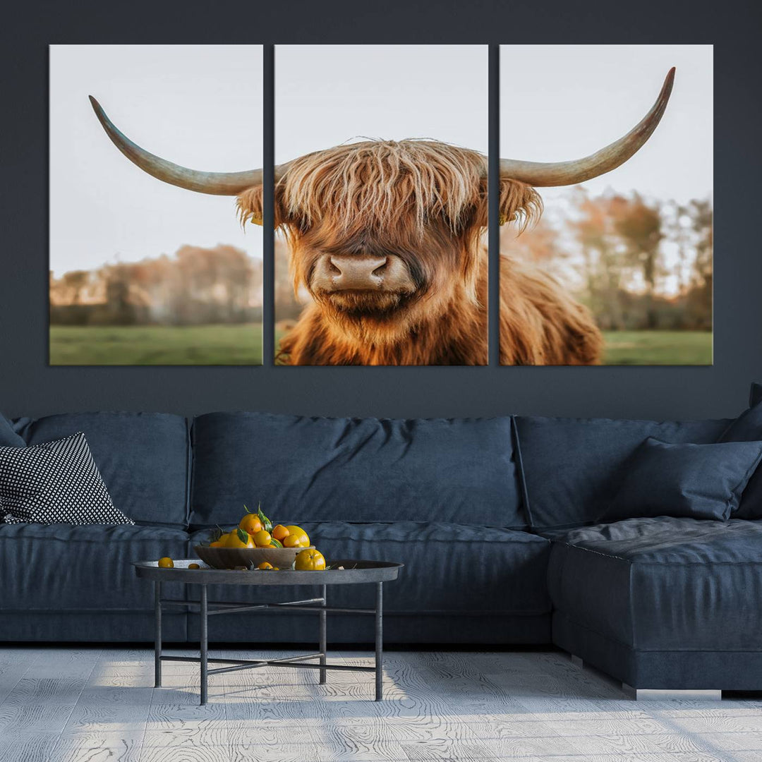 A Highland Cow Animal Scottish Cattle Art Print Farmhouse Wall Art Canvas Print hangs in the living room, adding a touch of rustic farmhouse decor.