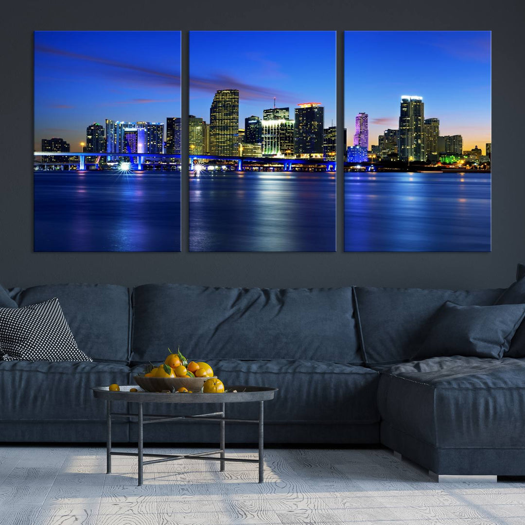 The modern living room showcases a striking Miami Blue Night Wall Art canvas print on the wall. The artwork is gallery wrapped on museum-quality canvas, ensuring durability and elegance.