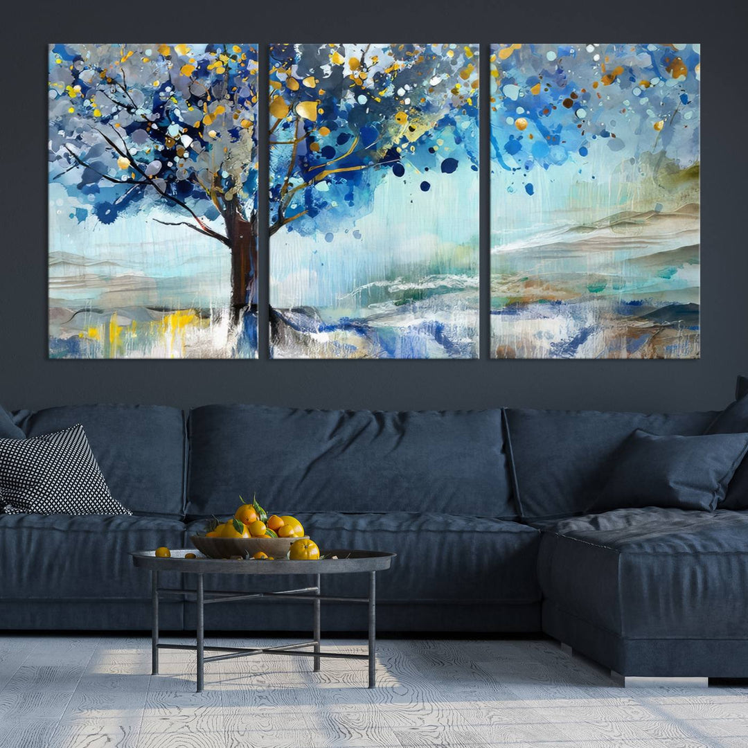 A modern living room features a three-panel Watercolor Style Abstract Tree Printing Wall Art Canvas in vibrant blue and yellow, crafted on museum-quality material.