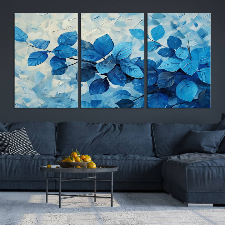 The contemporary living room is highlighted by the Abstract Blue Leaf Wall Art Canvas Print on the wall. The hand-assembled framed art enhances the room's vibrant decor, crafting a gallery-worthy ambience.