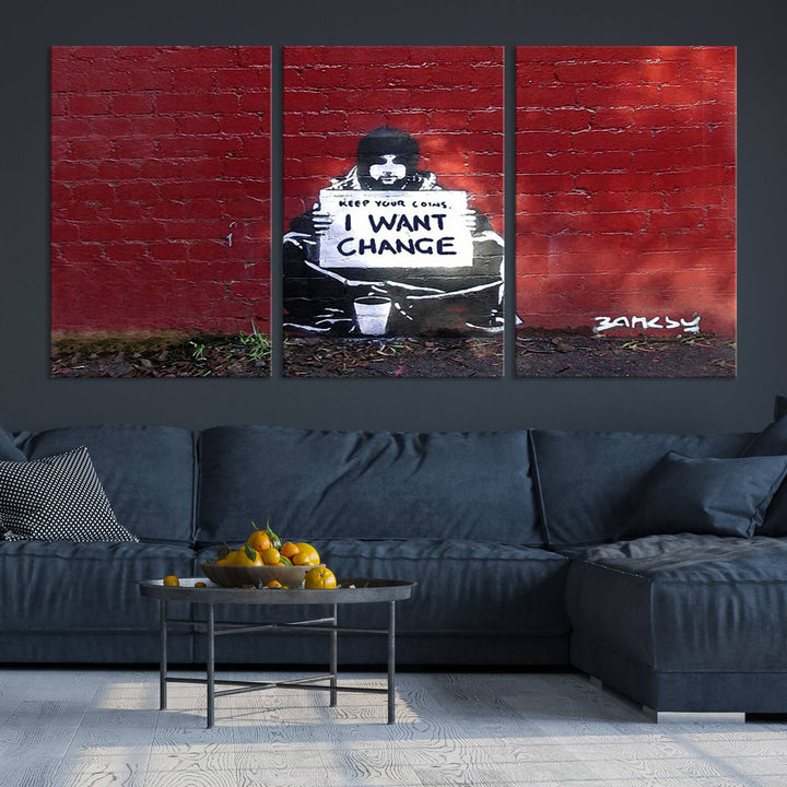 The living room showcases a triptych of stencil artwork on museum-quality canvas, featuring the Banksy I Want Change Graffiti Abstract Wall Art Canvas Print. This captivating piece depicts a person holding a sign that says "I want change" and is finished with a UV-protective coating to ensure long-lasting beauty.