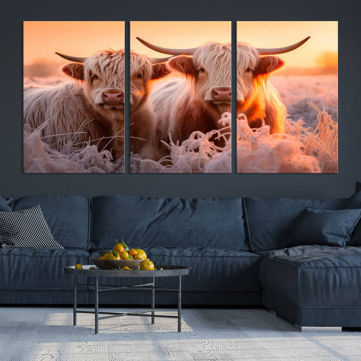 The "Highland Cows at Sunrise Wall Art Canvas Set" beautifully captures a serene and rustic farmhouse aesthetic, portraying two Highland cows in a frosty landscape at sunrise.