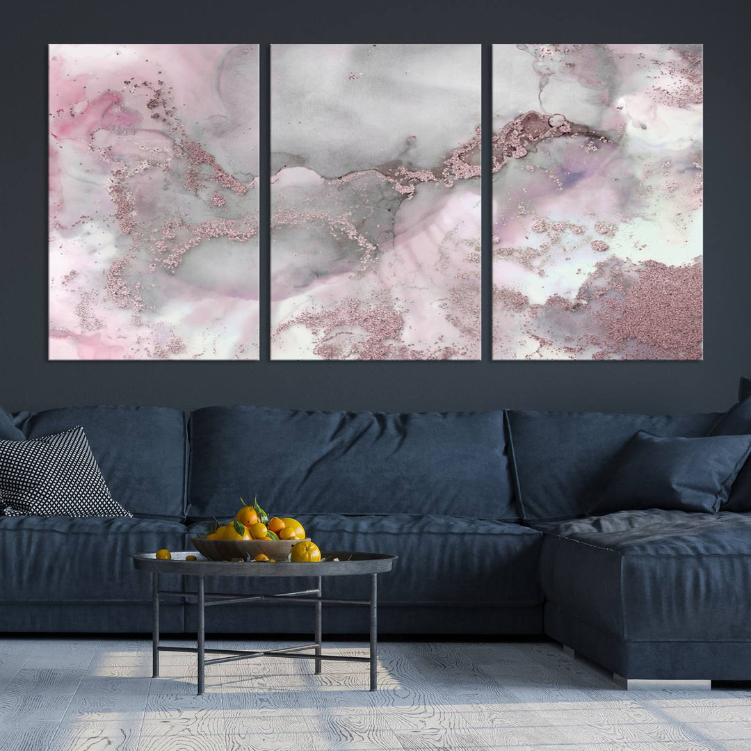 The Rose Marble Abstract Wall Art Canvas Print is a stunning triptych that showcases pink and gray tones, elegantly presented on a dark wall.