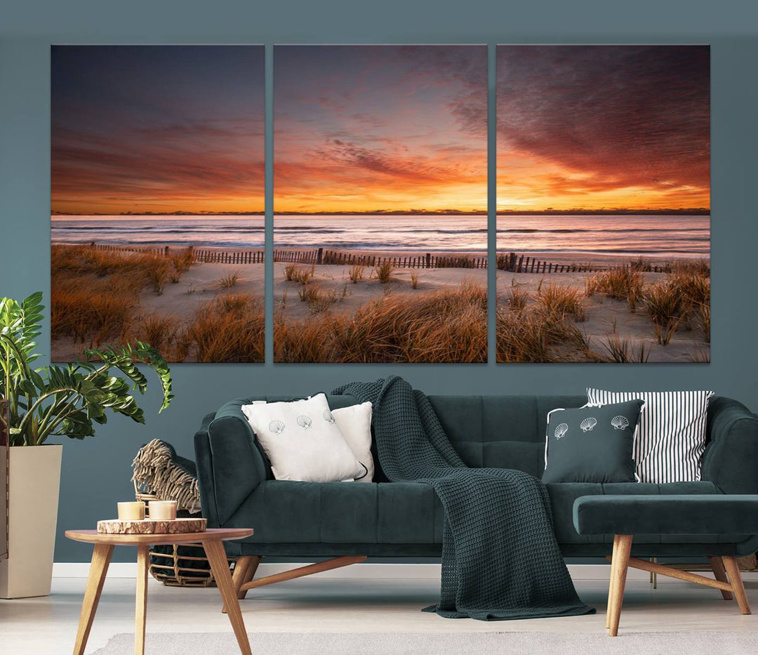 Sunset on The Beach Wall Art Canvas Print features a triptych of a beach at sunset with vivid orange skies, presented on museum-quality canvas. Each section is gallery wrapped, offering lasting beauty with its UV-protective coating.