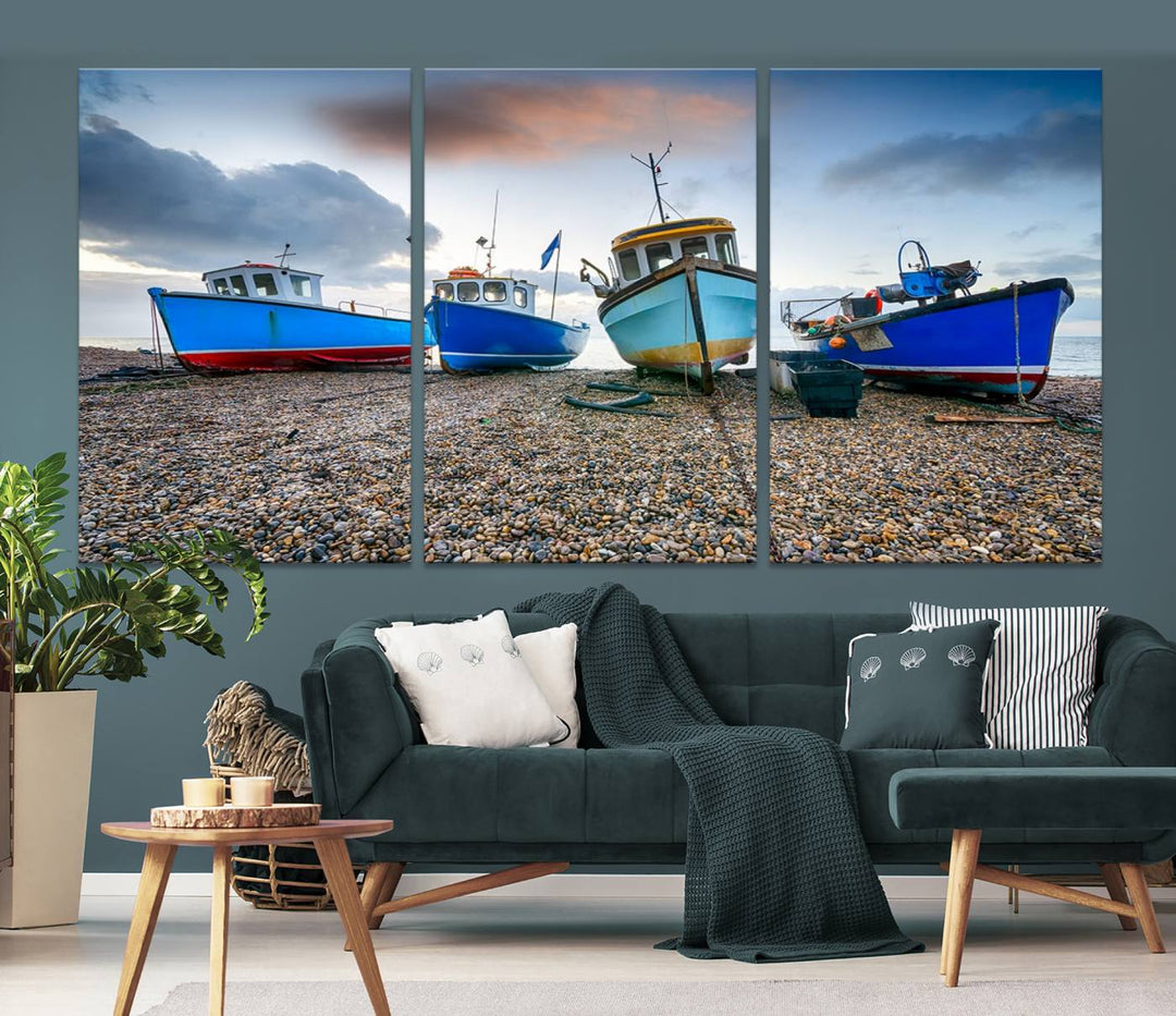 The "Big Boats On The Beach Wall Art Canvas Print" is a stunning piece featuring three museum-quality panels depicting fishing boats on a pebbled shore. Ready to hang and featuring UV-protective coating, it serves as an elegant addition to your home décor.