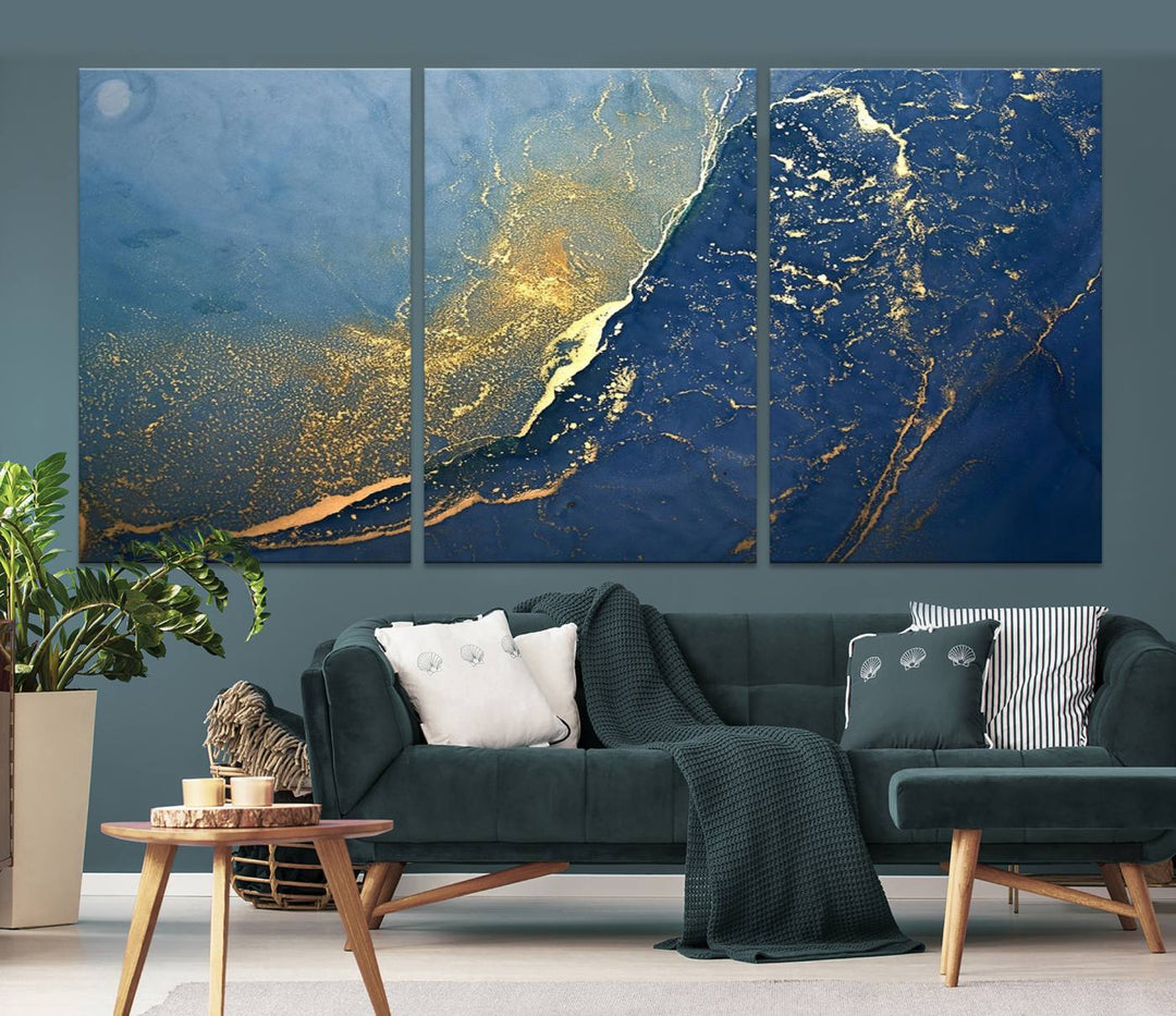 The Navy Blue Yellow Twinkle Wall Art Canvas Print, featuring an abstract design in gold and blue, enhances a modern living room as it adorns a white wall with its gallery-wrapped, museum-quality canvases for an exquisite touch.