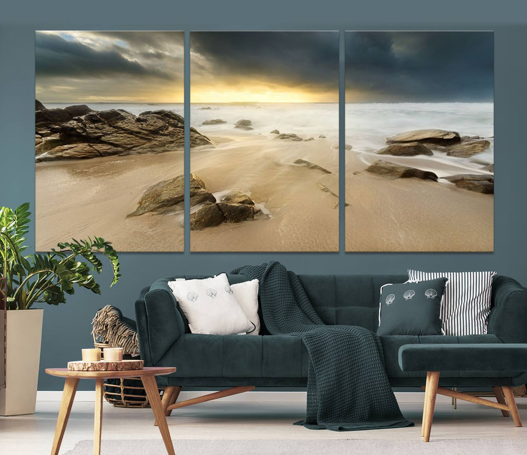 A gallery-wrapped, three-panel artwork titled "Rocks and Waves Wall Art Canvas Print" depicts a rocky beach at sunset. Each canvas showcases museum-quality craftsmanship and a UV-protective coating to maintain its vibrant colors.