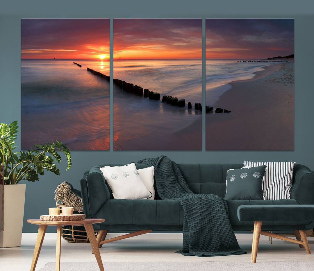 In a modern living room, the Sunset Beach Wall Art Canvas Print is displayed above. This triptych, printed on museum-quality canvas with a UV-protective coating, ensures lasting brilliance. It's ready to hang and brings an elegant touch to your space.