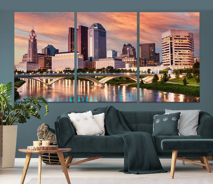 The "Columbus City Lights Sunset Orange Cloudy Skyline Cityscape View" wall art is featured on the wall. This triptych is printed on museum-quality canvas and includes a UV-protective coating, ensuring lasting vibrancy.